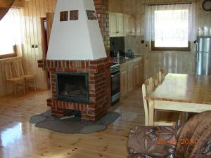 a kitchen with a brick fireplace in the middle of a room at Choszczogród in Sierakowice
