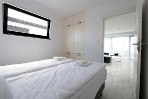グジボボにある5 Zmysłów akademia wypoczynku Domkiの白いベッドルーム(大型ベッド1台、窓付)