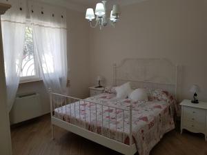 - une chambre blanche avec un lit et un lustre dans l'établissement Villa Venus Woods, à Martina Franca