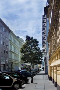 a sign for a hotel on a street with parked cars at Pension Pharmador in Vienna