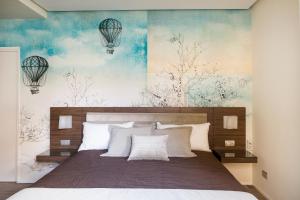 ローマにあるRhome Suitesのベッドルーム1室(白い枕と絵画付)