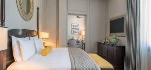 A bed or beds in a room at The Strand, Yangon