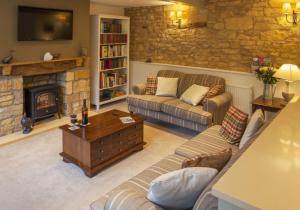 a living room with a couch and a fireplace at Hook Cottage in Chipping Campden