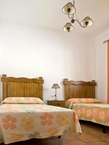 コニル・デ・ラ・フロンテーラにあるCasa Marinasのベッドルーム1室(ベッド2台、シャンデリア付)