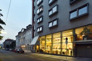 ein Gebäude mit vielen Fenstern auf einer Straße in der Unterkunft Hotel Korotan in Wien