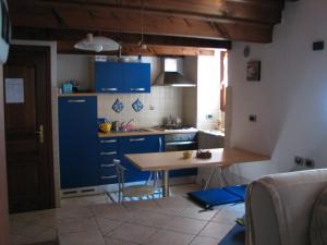 cocina con armarios azules y mesa de madera en B&B Vecchio Torchio, en Bard