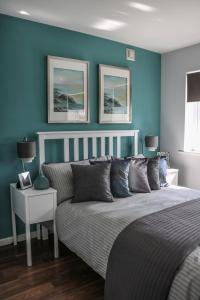 a bedroom with a bed and a blue wall at Ludwina House in Birmingham