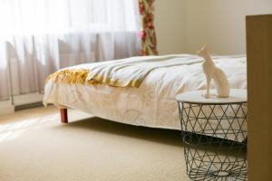 a cat statue sitting on a table next to a bed at Apartment Blaumana 6 in Riga