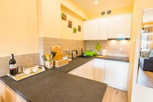 a kitchen with white cabinets and a counter top at Apartament Sweet Home in Krynica Zdrój