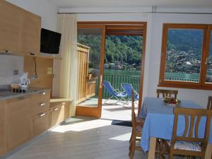 a kitchen with a table and a view of a balcony at Appartamenti Chalet al Lago in Alleghe
