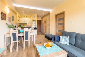 a living room with a blue couch and a table at Apartament Sweet Home in Krynica Zdrój