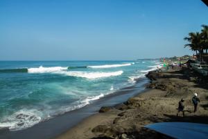 two people walking on the beach near the ocean at Bima Sakti Homestay Echo Beach Canggu in Canggu