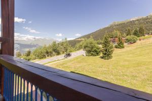 a balcony with a view of a field and mountains at Residence Pierra Menta in Arc 1800