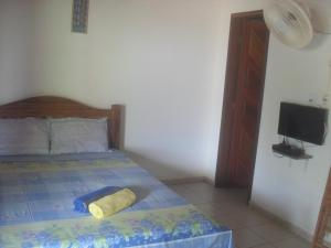 a bedroom with a bed with a tv on the wall at Pousada Flanboyan in São Miguel do Gostoso