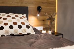 Cama con almohada de lunares y mesa en Boutique Hotel Chalet Weinberg en Würgau