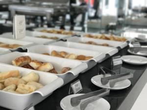 a bunch of pastries in trays on a counter at COBH Hotel in Caruaru