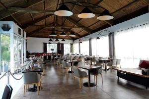 Un comedor con mesas y sillas y ventanas. en Atlantis, en Antananarivo