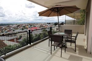 a balcony with a table and chairs and an umbrella at Atlantis in Antananarivo
