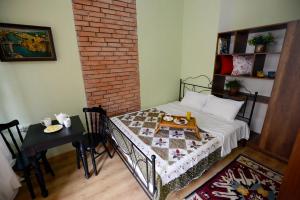 a room with a bed and a table and a brick wall at Atlant Hotel in Tbilisi City