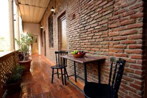 a room with a brick wall and a table with chairs at Atlant Hotel in Tbilisi City
