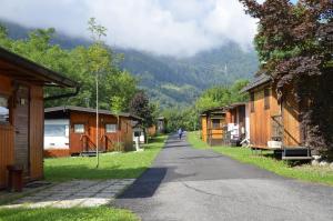 a path through a village with wooden buildings at Camping Adamello in Edolo