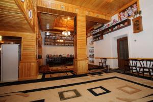 a room with wooden walls and a kitchen with a refrigerator at Furkat Guest House in Samarkand