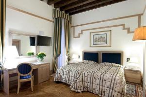 
a bedroom with a bed, chair and a lamp at Foscari Palace in Venice
