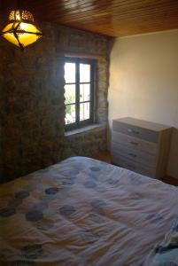 1 dormitorio con cama, ventana y vestidor en gîte de la garde, en Prévenchères