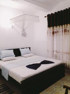 1 dormitorio con 1 cama blanca grande con cortinas en Royal Resort en Weligama