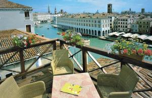 
a patio area with chairs, tables, and a balcony at Foscari Palace in Venice
