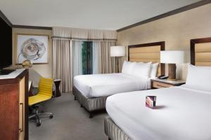 a hotel room with two beds and a yellow chair at Crowne Plaza Resort Asheville, an IHG Hotel in Asheville