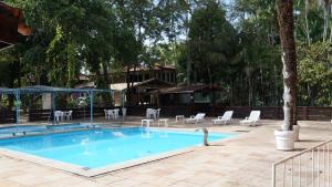 a swimming pool with chairs and tables and a house at Ceta Ecotel in Macapá