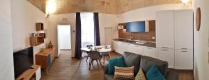 een woonkamer met een tafel en een keuken bij Borgo Guesthouse in Monopoli