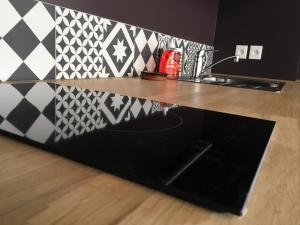 a kitchen counter with a black counter top with black and white tiles at Quintessens in Marseille