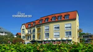 a large yellow building with a red roof at Hotel Starnberger See in Starnberg