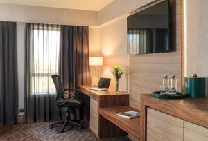 a hotel room with a desk with a laptop and a chair at Hotel Regal Pacific Santiago in Santiago