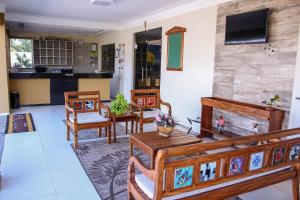 uma sala de estar com mobiliário em madeira e uma cozinha em Pousada Itarema Residence em Itarema