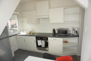 a kitchen with white cabinets and a stove top oven at Gründauer Schlafstub in Gründau