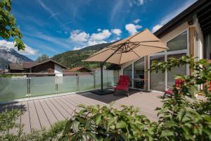 a patio with a chair and an umbrella at Panoramablick in Schruns-Tschagguns