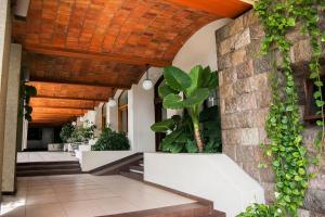 an indoor courtyard with plants and a wooden ceiling at Hotel Fortin Plaza in Oaxaca City