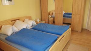 a bedroom with two beds with blue sheets and a mirror at Ferienhaus Raiter Südsteiermark in Weitersfeld an der Mur