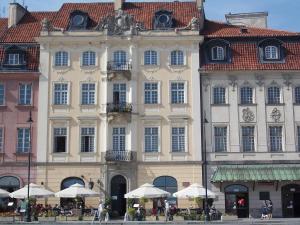 a large building with white umbrellas in front of it at Pokoje Gościnne Dom Literatury in Warsaw