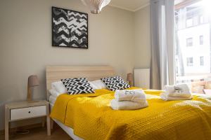 - une chambre avec un lit jaune et des serviettes dans l'établissement Rezydencja Park Rodzinna - FAF, à Mielno