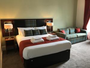 a hotel room with a large bed and a couch at The Crags Hotel in Callander