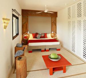 une chambre avec un lit et une table avec un bol de fruits dans l'établissement Les Manguiers de Guereo, à Guéréo