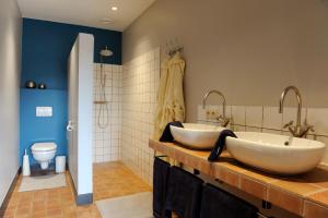 un bagno con due lavandini e un water di Logies De Hessie a Turnhout