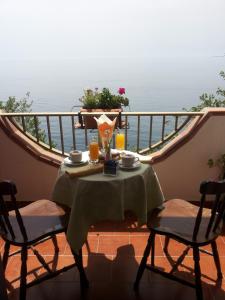 a table and chairs on a balcony with the ocean at Camere Santa Margherita in Santa Margherita-Sant'Alessio Siculo