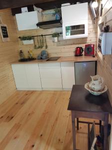 a kitchen with white cabinets and a wooden floor at Domek pod śnieżką 1 in Karpacz