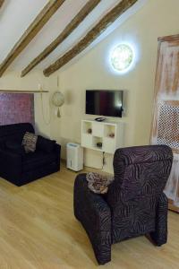 ein Wohnzimmer mit einem Stuhl und einem TV in der Unterkunft Loft "Elegante" Lila in Ubrique