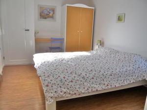 エグモント・アーン・ゼーにあるZomerhuisje bij Zeeのベッドルーム1室(花柄のベッドカバー付)